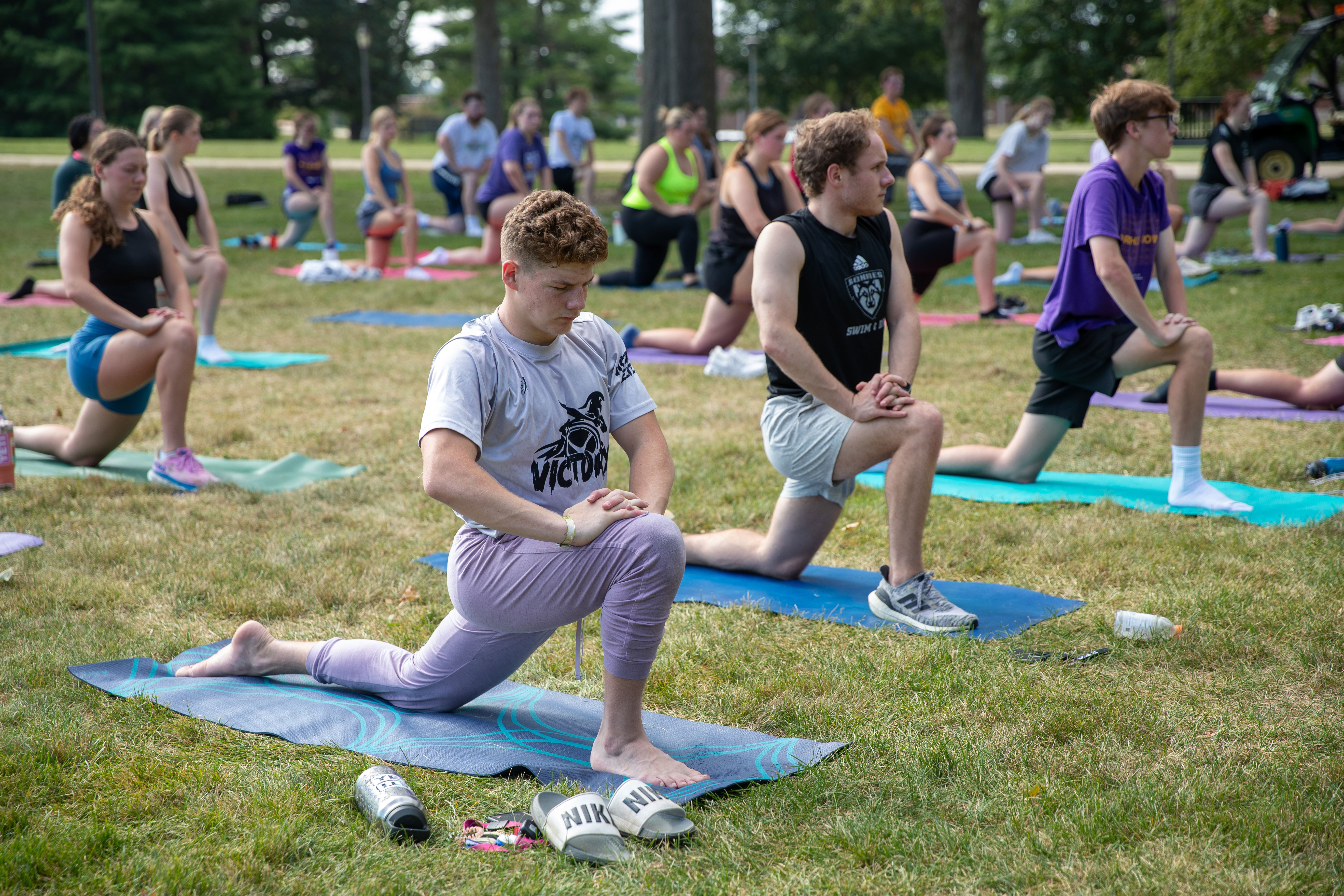 Students doing yoga class outside. 