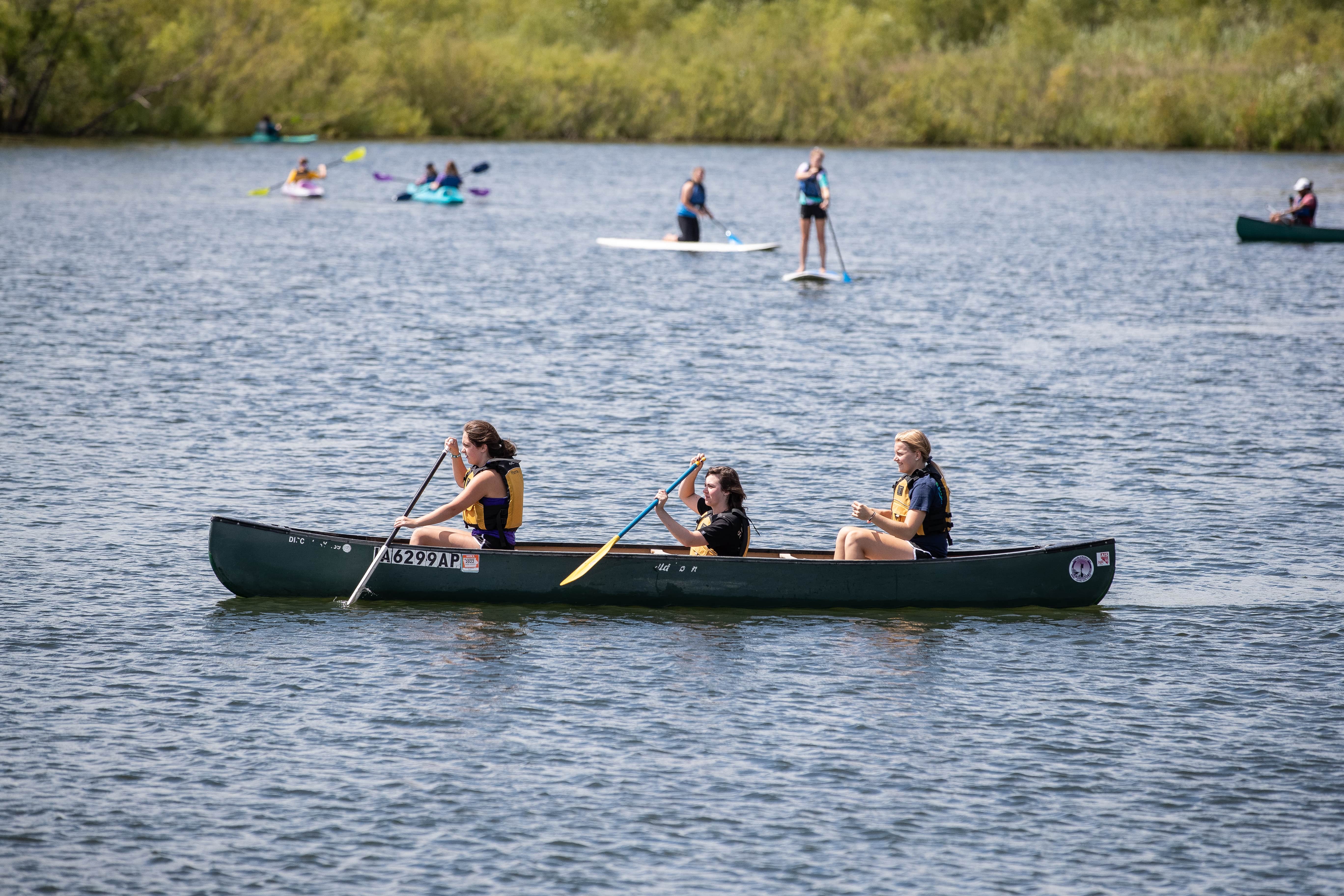 Students canoeing on the pond. 