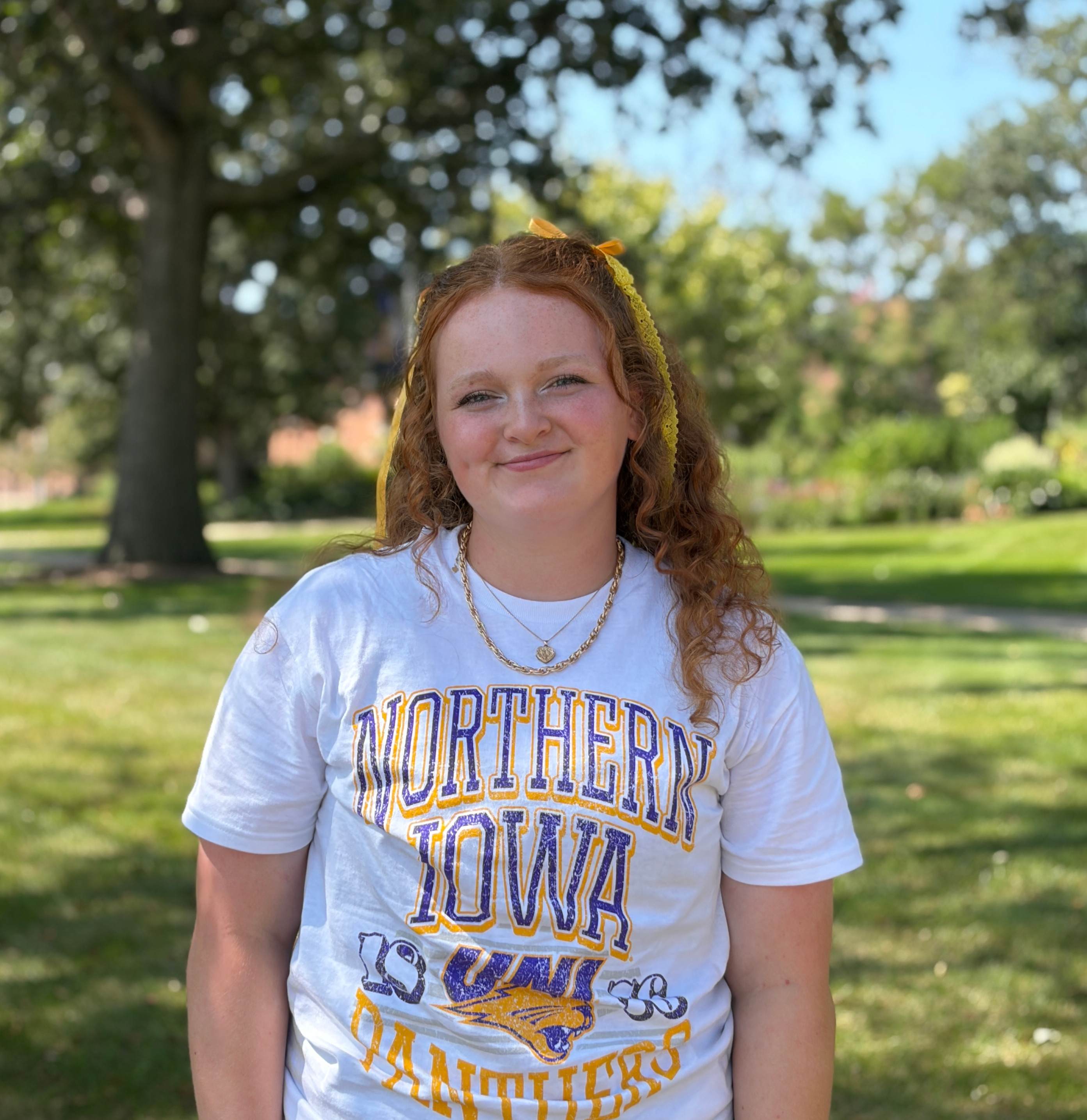 Caitie smiling wearing UNI shirt