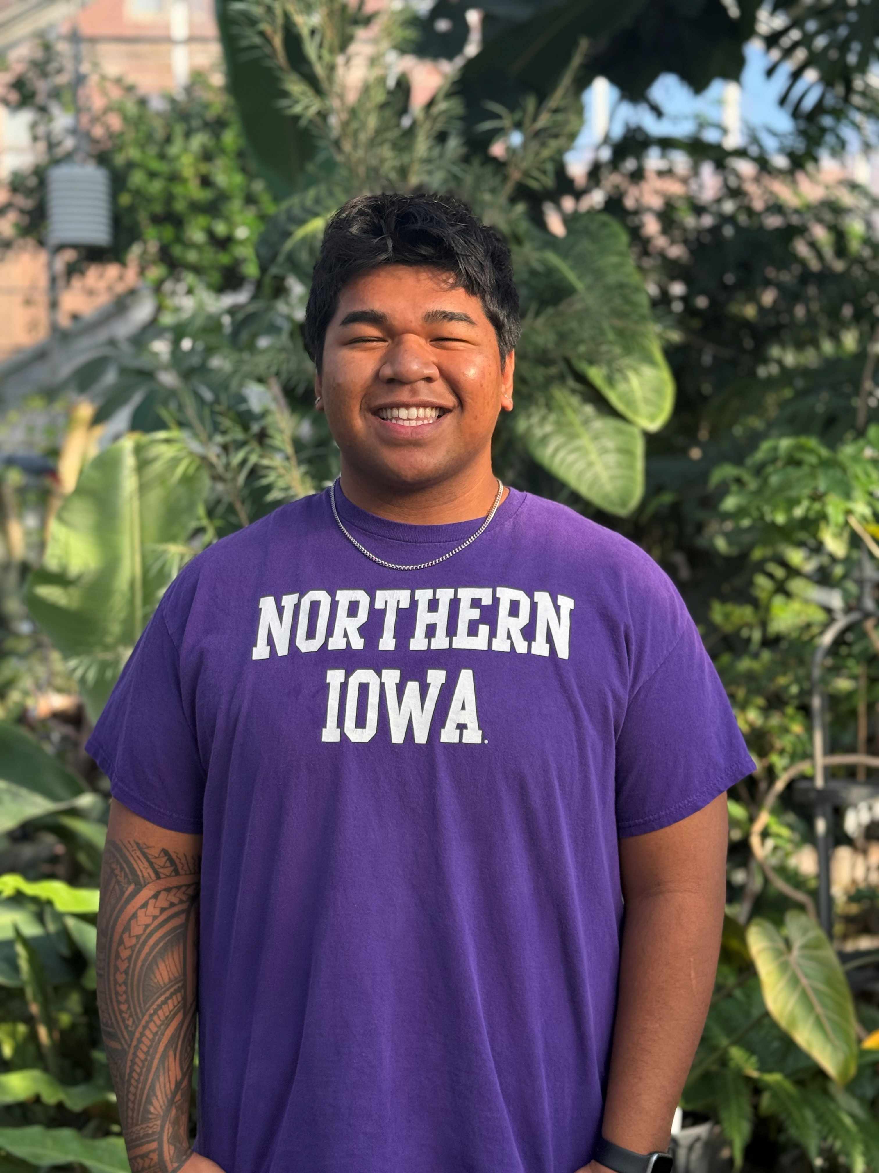 Daniel smiling in purple Northern Iowa shirt
