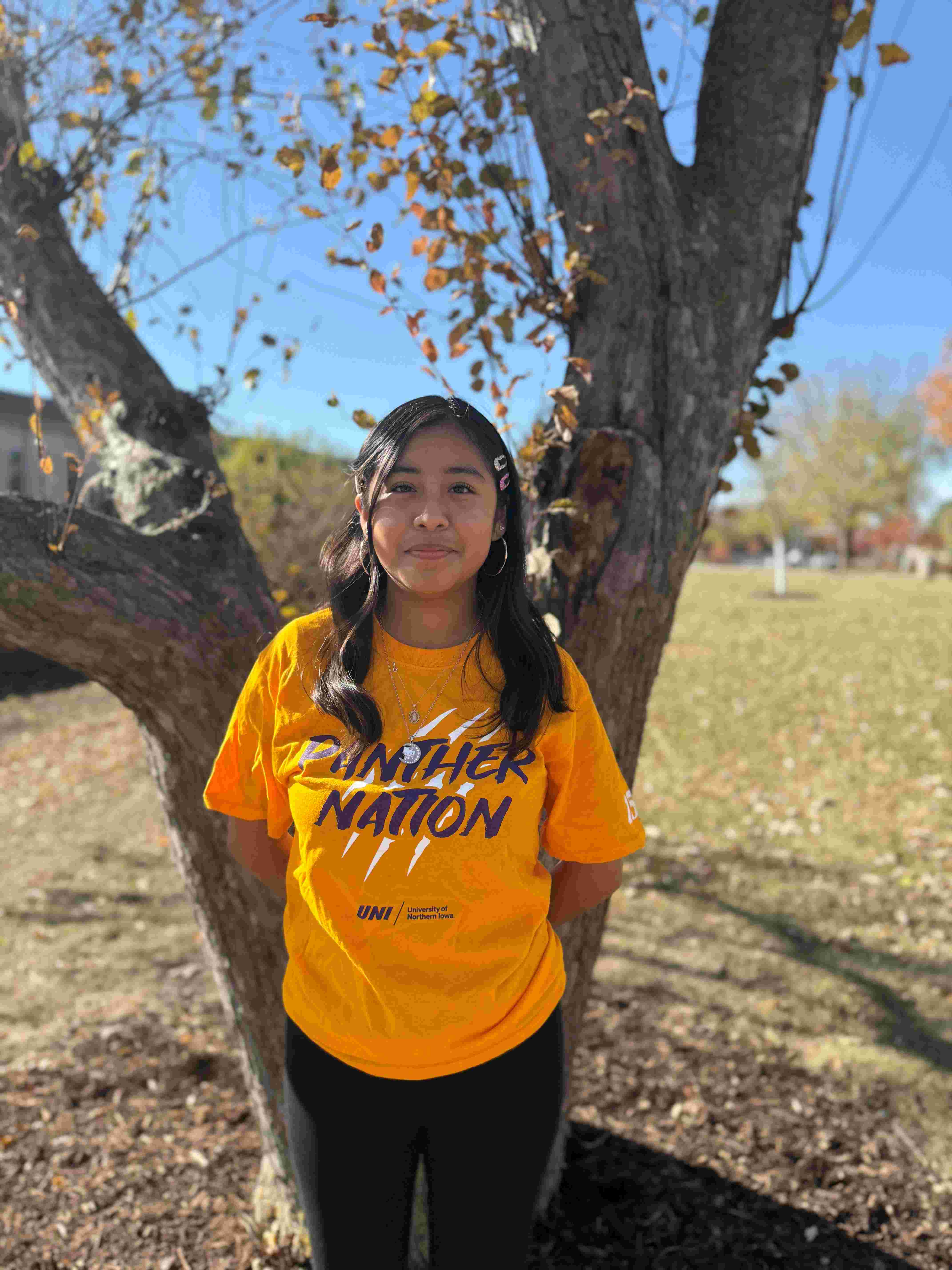 Ozmery wearing gold "Panther Nation" shirt