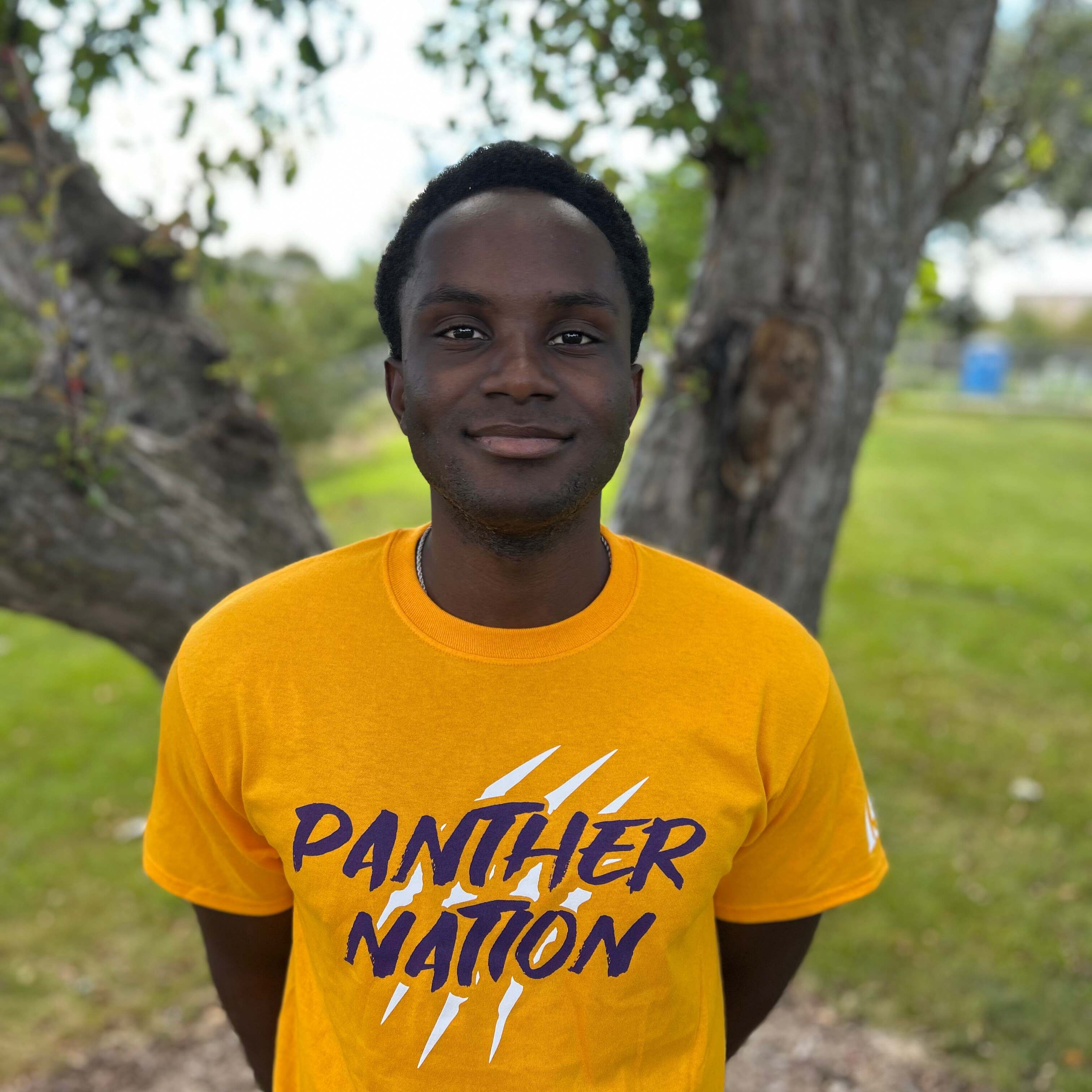 ishimwe wearing gold panther nation shirt