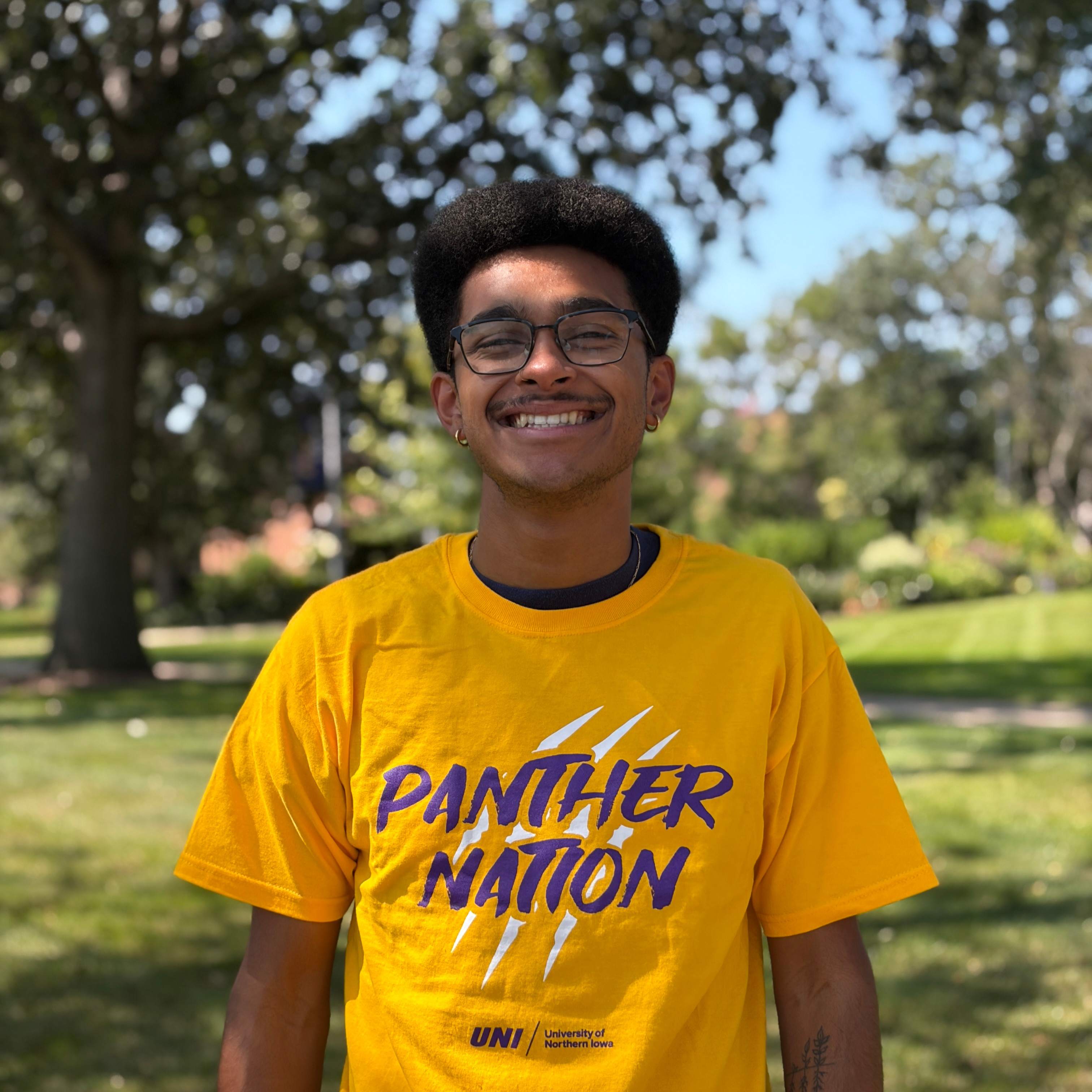 Tyson smiling wearing gold shirt