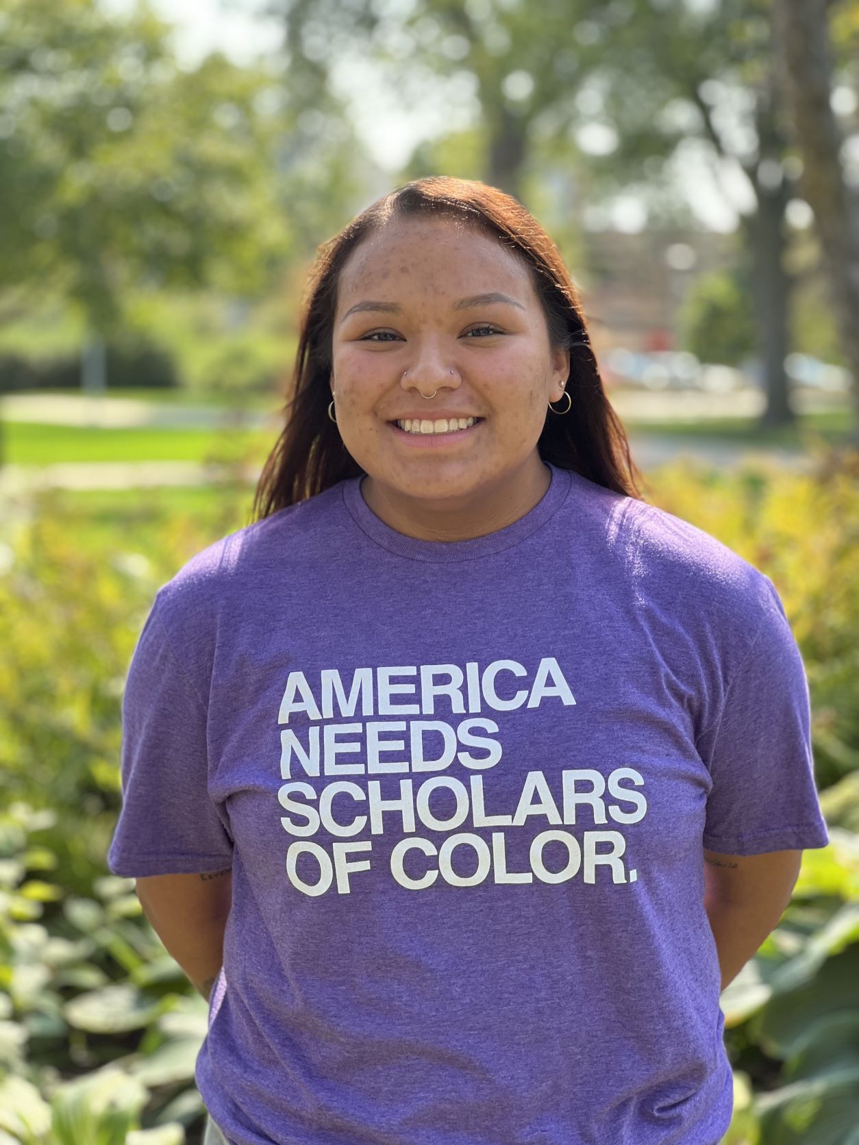 Marley in purple UNI shirt that reads America Needs Scholars of Color. 