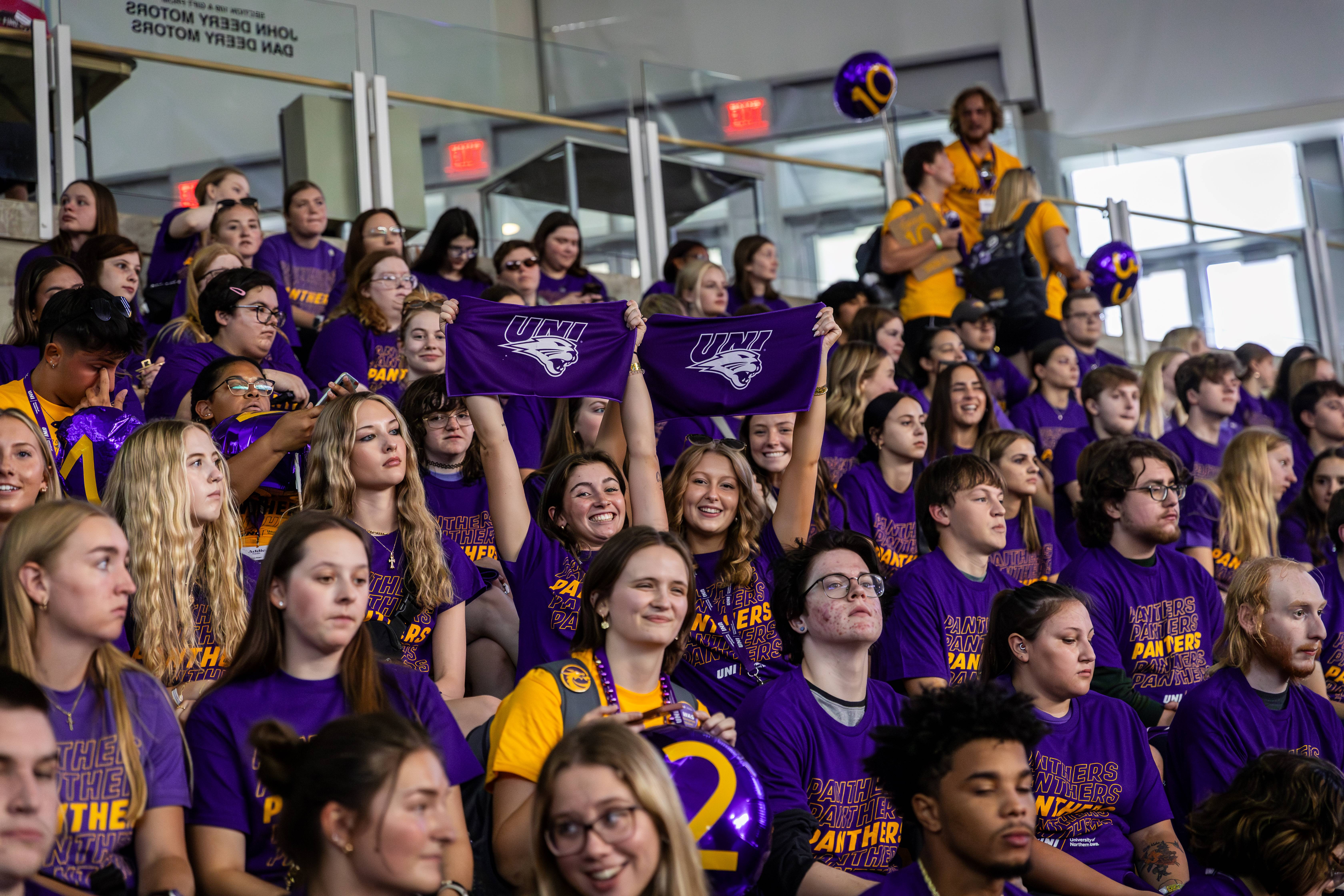 Students holding up UNI rally towels in bleachers